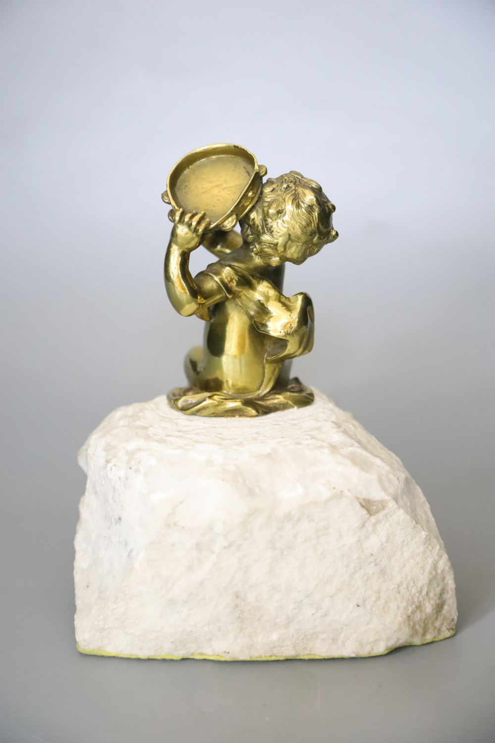 An ormolu seated tambourinist, on granite plinth, 19cm